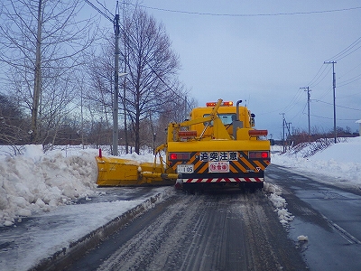 歩道の積雪を排除している除雪専用車の写真