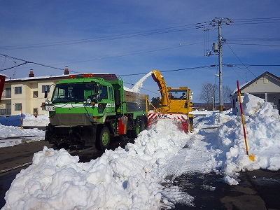 道路脇の排雪作業をしているロータリー車の写真