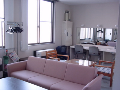 ピンクのソファが置かれている洋室の楽屋の写真