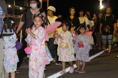 浴衣を着て歩いている子供たちと保護者たちの写真