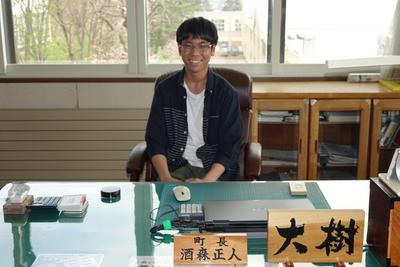 町長の椅子に座っている松本大樹さんの写真