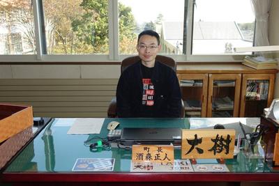 町長の椅子に座っている佐藤大樹さんの写真