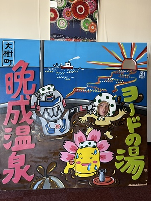 ヨードの湯 晩成温泉と書かれた顔ハメ写真撮影スポットでの選手の写真