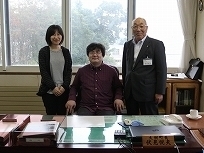 町長の椅子に座っている藤原大樹さんと女性と町長の写真