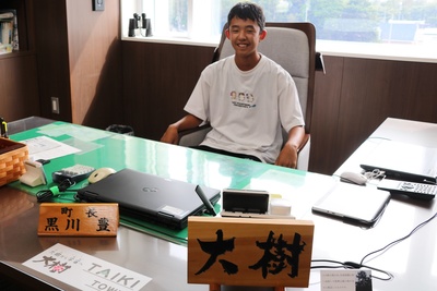 町長の椅子に座っている藤山大樹さんの写真
