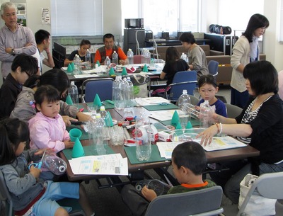 日本宇宙少年団大樹分団の総会でペットボトルロケットの制作をしている子供たちと講師の人たちの写真