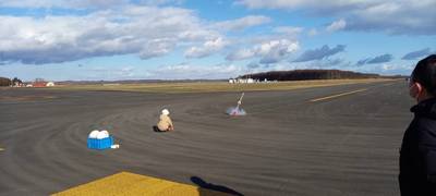 滑走路上にてモデルロケットの打ち上げを試みる団員の写真