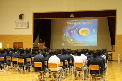体育館のステージ上でスライドショー形式にて進行する、「地域人材等を活用した講演会」の講演風景の写真