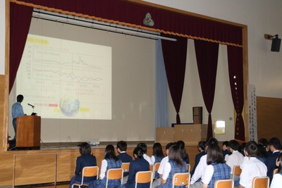 体育館のステージ上でスライドショー形式にて進行する、「地域人材等を活用した講演会」の講演風景の写真