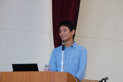 ステージ上の演台にて講演を行う小財氏の写真