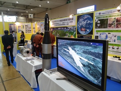 ビジネスEXPOで展示されている観測ロケットモモや人口衛星軌道投入ロケットの模型の写真