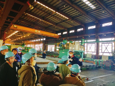 釧路製作所の工場内を見学する団員たちの写真