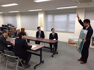 飛行管制棟内の一室にて着席して職員からの解説を聞く、北海道経済連合会・北海道電力・ノーステック財団の各訪問団の写真
