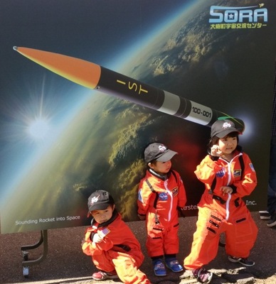宇宙服を着てポーズをとって記念撮影をしている子供たちの写真