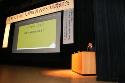 生涯学習センター内・コスモスホールのステージ上における、「大樹町教育の日講演会」の講演風景の写真