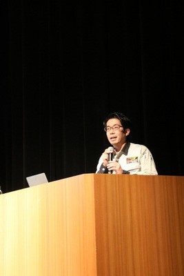 ステージ上の演台にて講演を行う金井竜一朗氏の写真