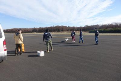 室蘭工業大学航空宇宙システム研究センターの研究員たちがオオワシ2号の縮小機体による実験をしている写真