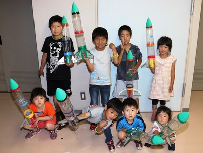 工夫を凝らした立派なロケットを持って記念撮影している写真