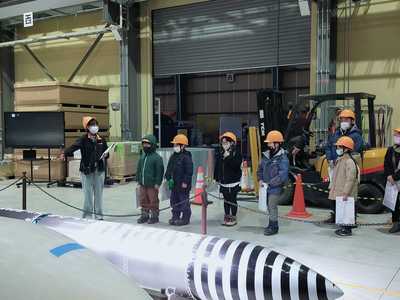 インターステラテクノロジズ社の工場内にてMOMO7号機の実機を見学する団員たちの写真