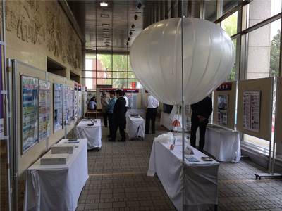 展示ブースに飾られたパネルやポスターを観覧している来場者の方々の写真