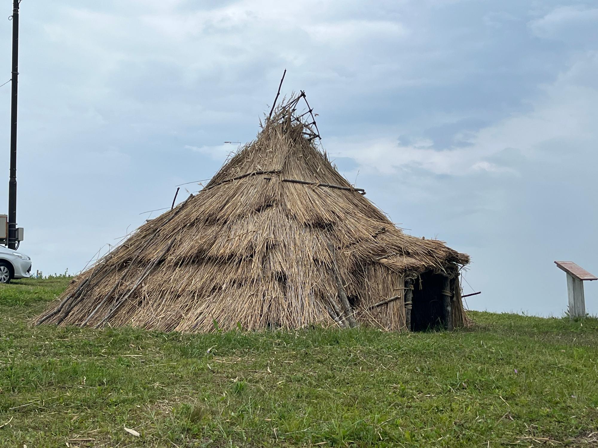 復元された茅葺のホロカヤントー竪穴式住居の写真