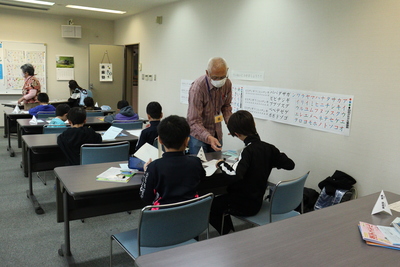 生涯学習センターの視聴覚室で子ども達に勉強を教える地域住民の写真
