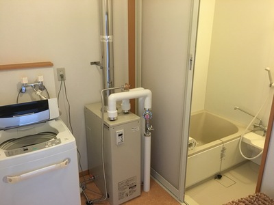 洗濯機やお風呂場が見える洗面所の写真
