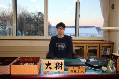 町長の椅子に座っている佐藤大樹さんの写真
