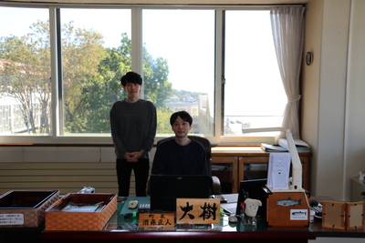 町長の席に座っている柴田大樹さんとご友人の写真