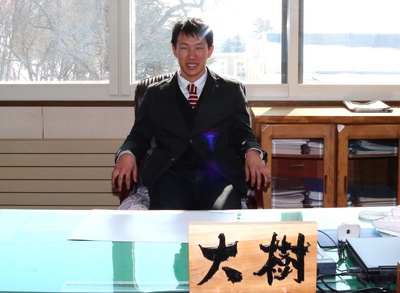 町長の椅子に座っている岡本大樹さんの写真