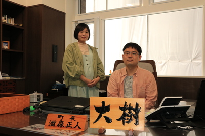 町長室で写真を撮っている東田大樹さんと奥様の写真
