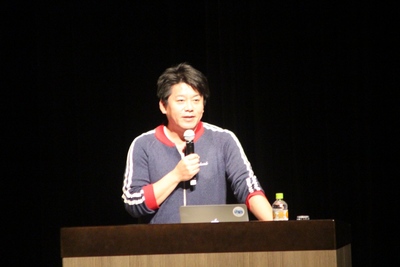 演台にて講演を行う堀江氏の写真