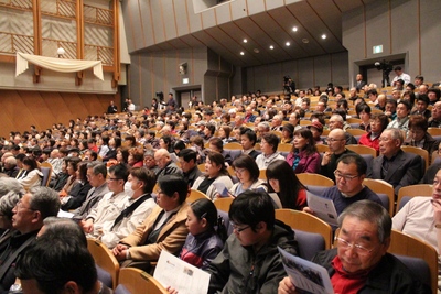 生涯学習センター内・コスモスホールの観覧席に座して講演を観覧する、大勢の来場者たちの写真