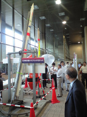 CAMUI型ハイブリットロケットと書かれたパネルが付けられた発射台に固定されたロケットの写真