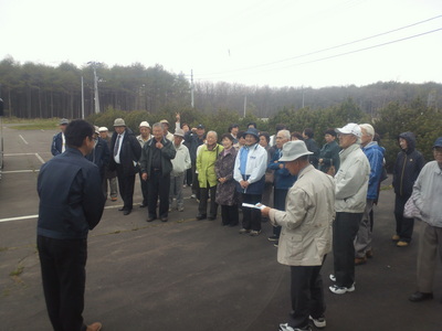 多目的航空公園の駐車場にて、職員からの説明を聞く広西親和会の訪問団一行の写真