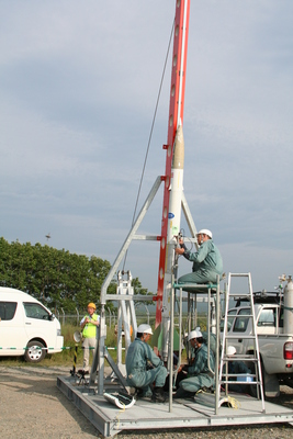 SNS製の液体ロケットを設置している職員の方たちの写真