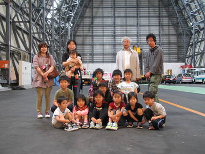大樹町多目的航空公園の格納庫内で座っているYACの子どもたちの写真