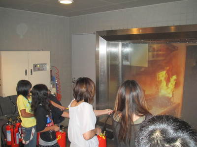 札幌市防災センター内の体験コーナーにて消火体験を試みる団員児童達の写真