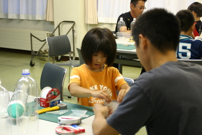 固定する作業に苦戦している子供たちの写真