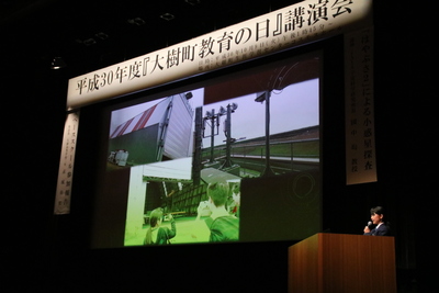 生涯学習センターのコスモスホールにて進行された、赤城氏による活動報告の講演風景の写真