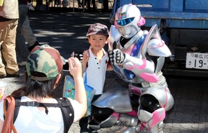 イベントに参加した幼児と共に記念撮影に応じるカムイリオンの写真
