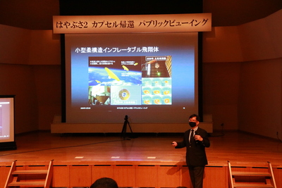 ステージ上の大型スクリーンに映し出される、パブリックビューイングの上映風景写真