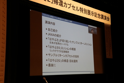 大型スクリーン上に投影された、山田和彦教授のリモート講演風景の写真