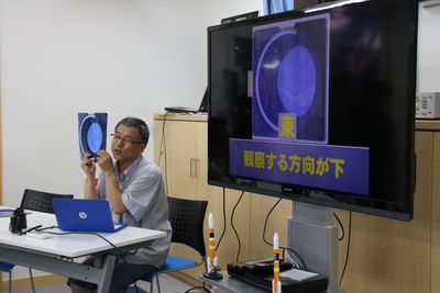 SORAの展示室2にて星座早見盤の使い方をレクチャーするスタッフの写真