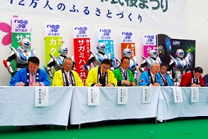 第43回相模原市民桜まつりにおける、カクダ共和国こと宮城県角田市の銀河連邦加盟調印式の様子をおさめた写真。写真中央に調印書に署名する角田市長（当時）・大友喜助氏の姿が確認出来る