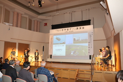 生涯学習センターにて上部に「たいき宇宙デー」と書かれたスクリーンへの投影を用いて行われているパネルディスカッションの様子の写真