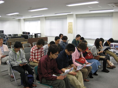 飛行管制棟内の一室にて、各々着席して手元の資料に目を通す帯広畜産大学の学生たちの写真