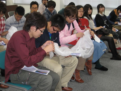 飛行管制棟内の一室にて気球のサンプルを手にしながら実権を試みる、帯広畜産大学の学生たちの写真