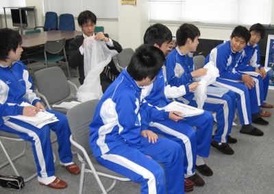 飛行管制棟内の一室にて気球のサンプルを手にしながら実権を試みる豊似中学校の生徒たちの写真